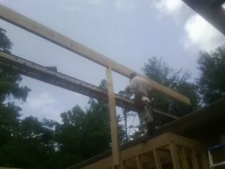 Carpenter setting a ridge beam over a new addition frame — Ice Dam Removal by Roofing Brothers in Parksville